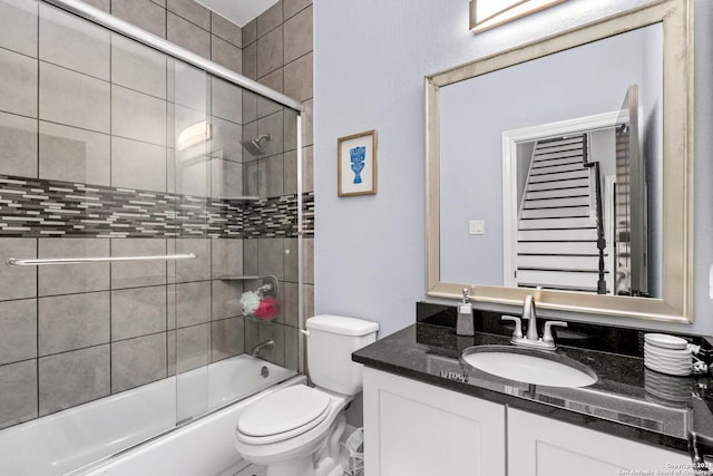 full bathroom featuring toilet, shower / bath combination with glass door, and vanity