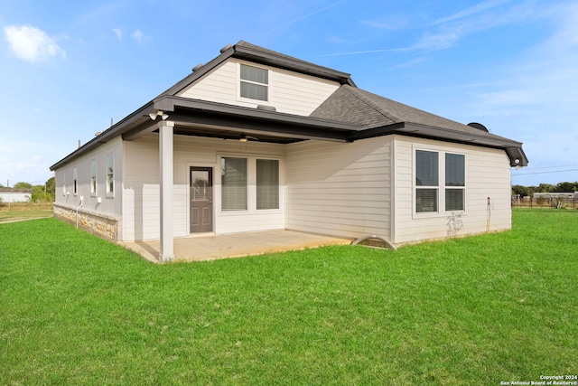 back of house featuring a patio area and a lawn