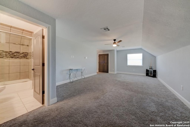 interior space with carpet floors, a ceiling fan, visible vents, and lofted ceiling