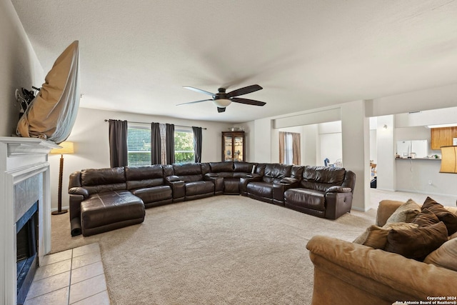 living room featuring a fireplace, light carpet, and ceiling fan