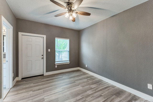 entryway with light hardwood / wood-style floors, ceiling fan, and a textured ceiling