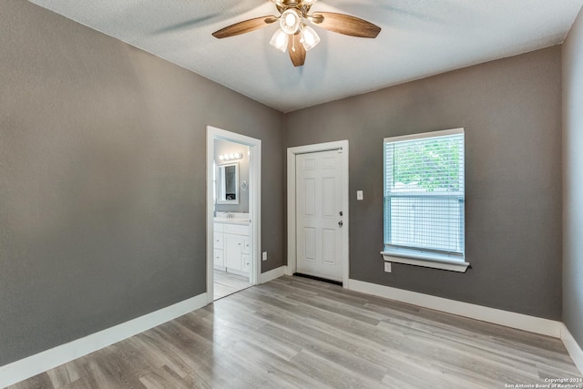 spare room featuring a textured ceiling, ceiling fan, and light hardwood / wood-style floors