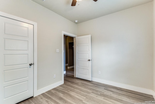 unfurnished bedroom with ceiling fan and light hardwood / wood-style flooring