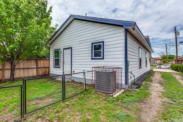 back of property with a lawn and central AC unit