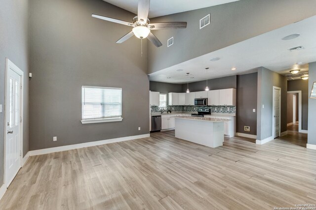 kitchen featuring sink, white cabinets, light hardwood / wood-style flooring, appliances with stainless steel finishes, and decorative light fixtures