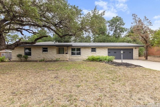 ranch-style house featuring a front yard and a garage