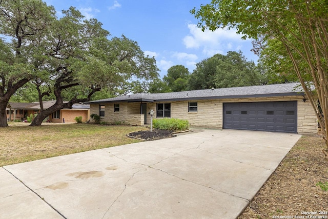 single story home with a garage and a front lawn