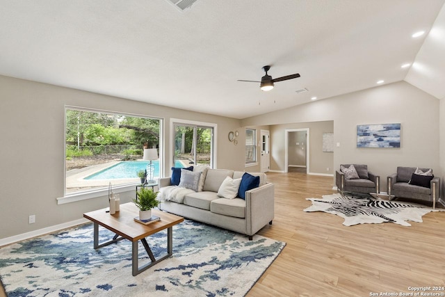 living room with light hardwood / wood-style flooring, vaulted ceiling, and ceiling fan