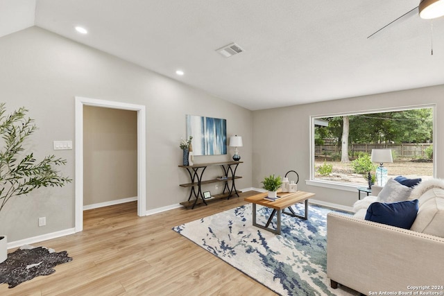 living room with light wood-type flooring, lofted ceiling, and a wealth of natural light