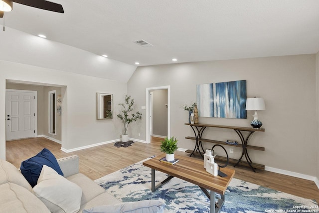 living room featuring hardwood / wood-style flooring, vaulted ceiling, and ceiling fan