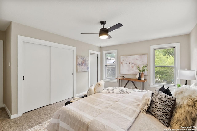 carpeted bedroom with ceiling fan and a closet