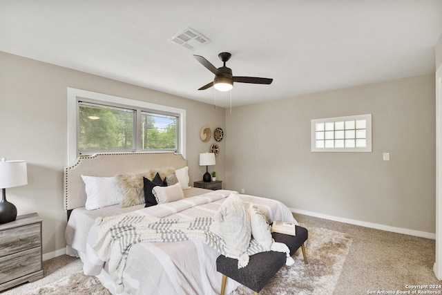 carpeted bedroom with multiple windows and ceiling fan