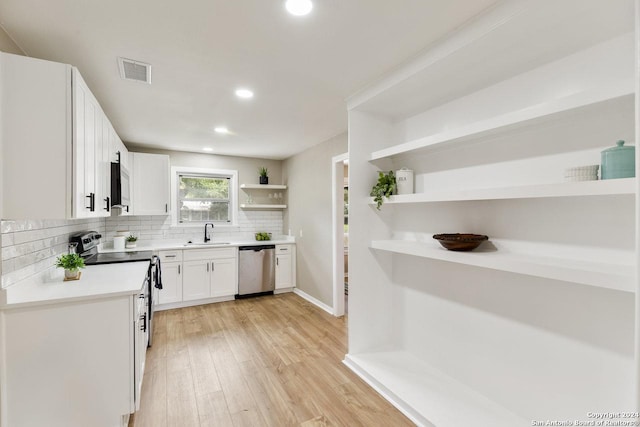 kitchen with white cabinetry, sink, stainless steel appliances, decorative backsplash, and light wood-type flooring