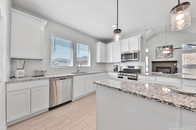 kitchen with white cabinets, decorative light fixtures, and appliances with stainless steel finishes