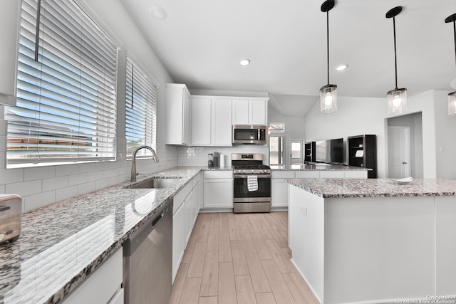 kitchen with pendant lighting, white cabinets, sink, appliances with stainless steel finishes, and tasteful backsplash