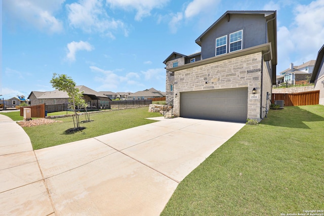 view of front of home featuring a front yard, a garage, and central AC unit