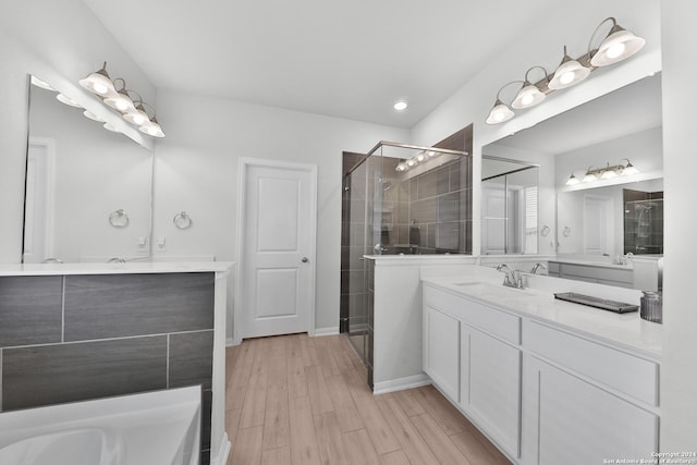 bathroom with hardwood / wood-style floors, vanity, and an enclosed shower