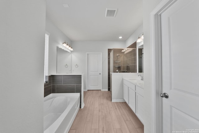 bathroom with vanity, independent shower and bath, and wood-type flooring