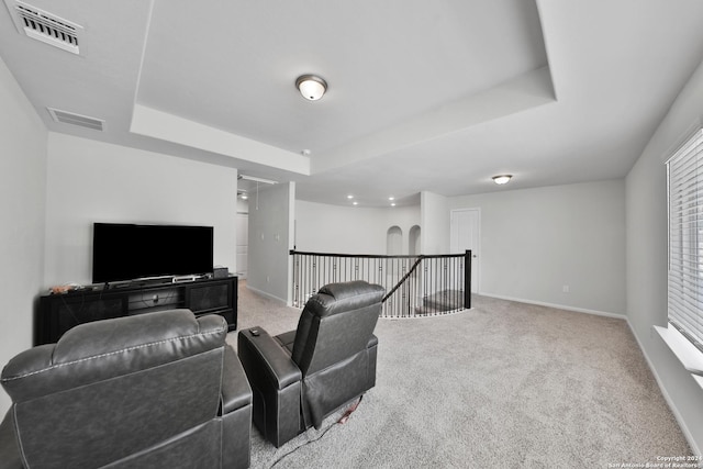 carpeted living room featuring a tray ceiling