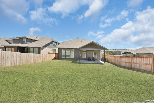 rear view of property featuring a lawn and a patio