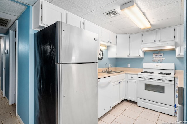 kitchen featuring white cabinetry, sink, white appliances, and light tile patterned flooring