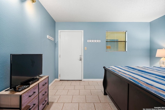 tiled bedroom featuring a textured ceiling