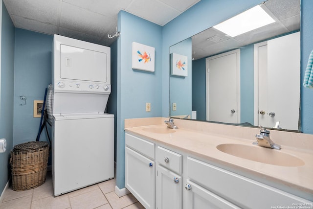 bathroom with tile patterned flooring, stacked washer and clothes dryer, a paneled ceiling, and vanity