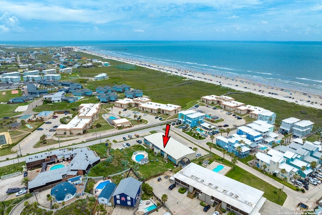 bird's eye view with a water view and a beach view