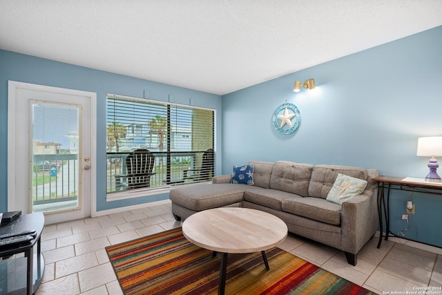 living room with a textured ceiling and light tile patterned floors