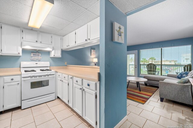 kitchen featuring white range with gas stovetop and white cabinetry