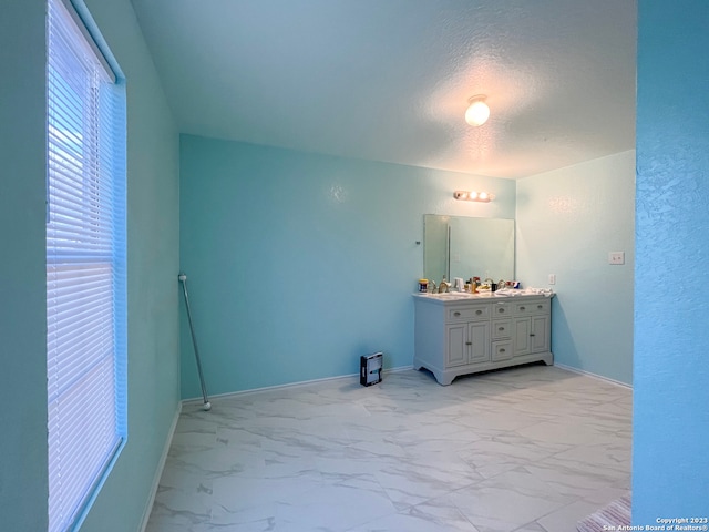 interior space featuring sink, light tile patterned flooring, and a textured ceiling