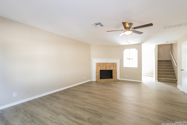 unfurnished living room with a fireplace, wood-type flooring, and ceiling fan