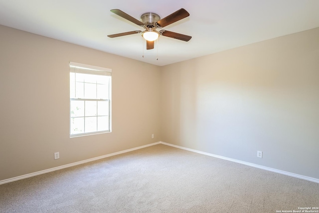 carpeted spare room featuring ceiling fan