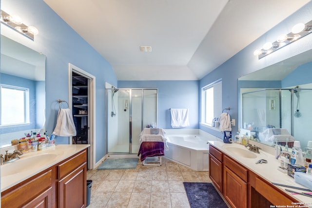 bathroom featuring double vanity, independent shower and bath, tile patterned floors, and a wealth of natural light