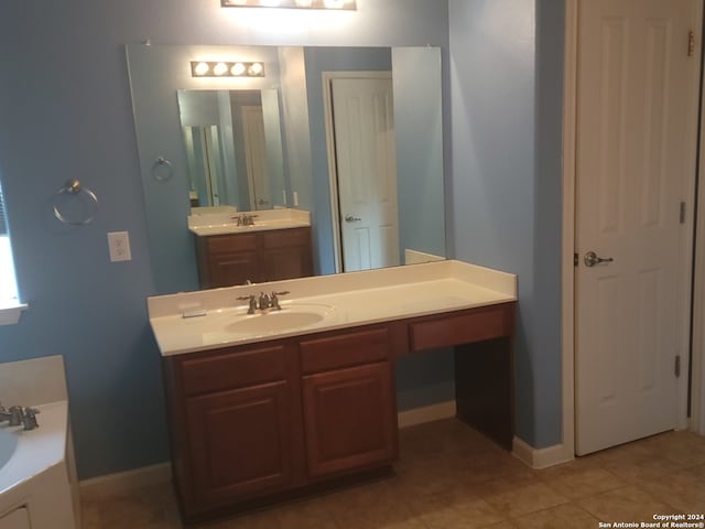 bathroom featuring tile patterned flooring, double vanity, and a bathing tub