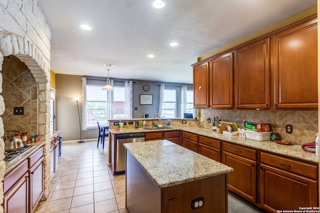 kitchen featuring stainless steel dishwasher, kitchen peninsula, sink, a center island, and light tile patterned floors