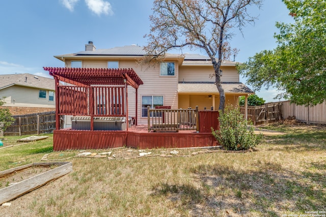 back of house featuring a pergola, a lawn, and a deck