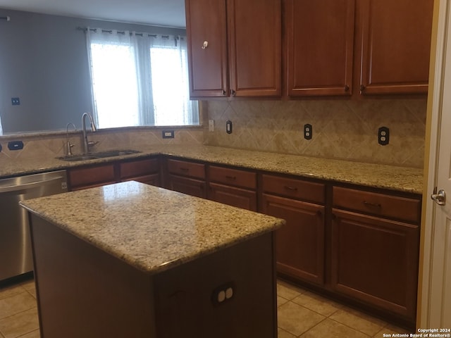 kitchen with light tile patterned floors, light stone counters, stainless steel dishwasher, decorative backsplash, and sink