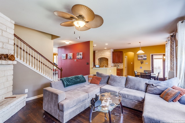 living room with brick wall, dark hardwood / wood-style flooring, and ceiling fan