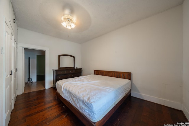 bedroom with dark hardwood / wood-style floors