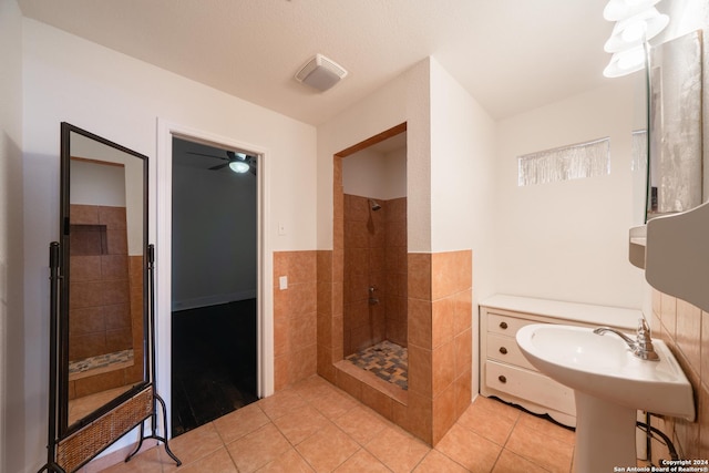 bathroom with tile walls, tile patterned floors, and tiled shower