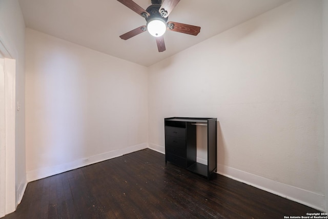 empty room with ceiling fan and dark wood-type flooring