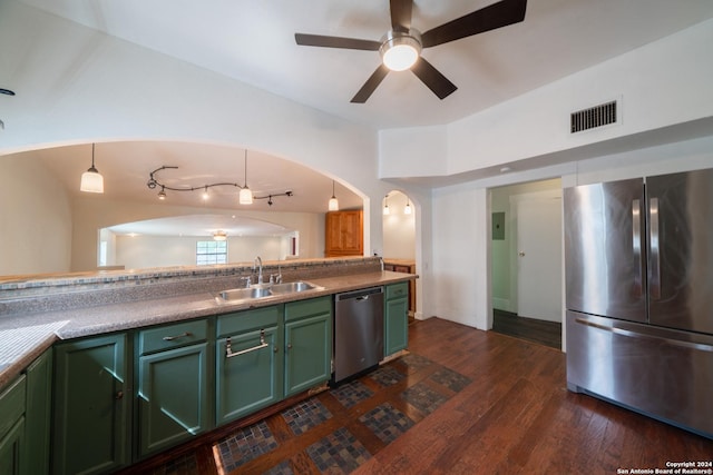 kitchen with sink, green cabinets, hanging light fixtures, appliances with stainless steel finishes, and dark hardwood / wood-style flooring