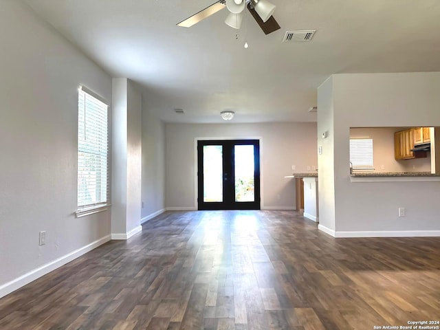 unfurnished living room with french doors, a wealth of natural light, ceiling fan, and dark hardwood / wood-style floors