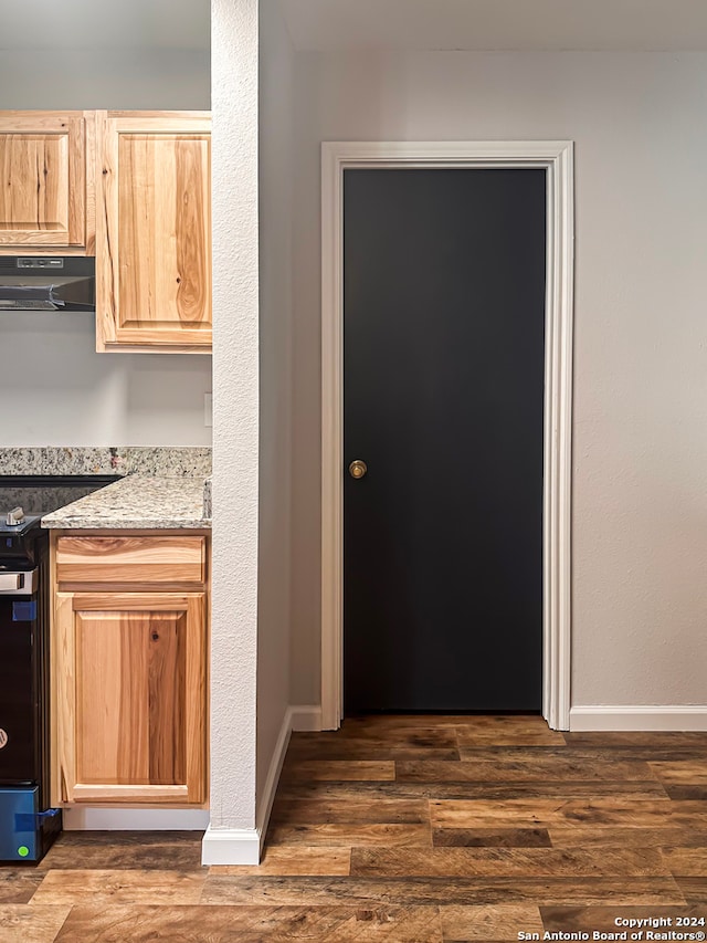 kitchen with light brown cabinetry and range with electric cooktop