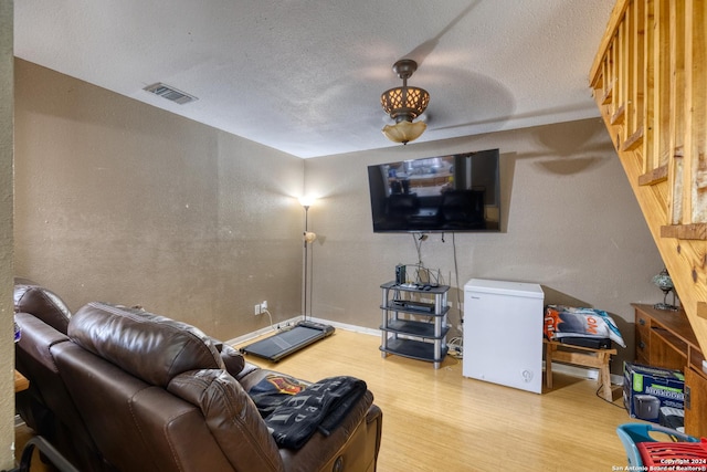 living room with hardwood / wood-style floors and a textured ceiling