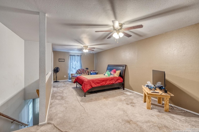 bedroom with ceiling fan, light carpet, and a textured ceiling