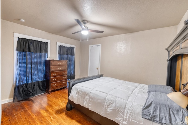 bedroom featuring hardwood / wood-style floors, ceiling fan, and a textured ceiling