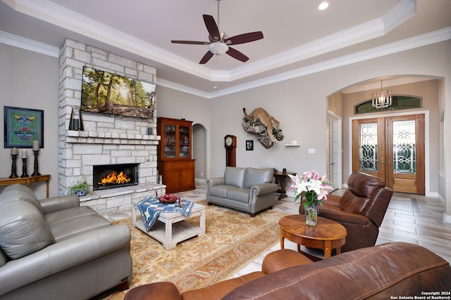 living room featuring ceiling fan, french doors, a tray ceiling, and ornamental molding