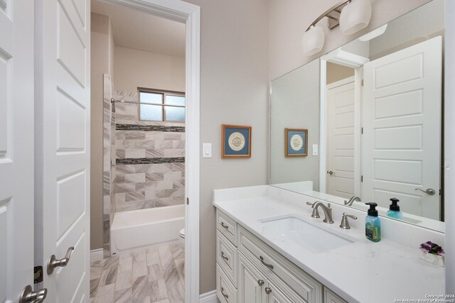 full bathroom with toilet, vanity, and tiled shower / bath